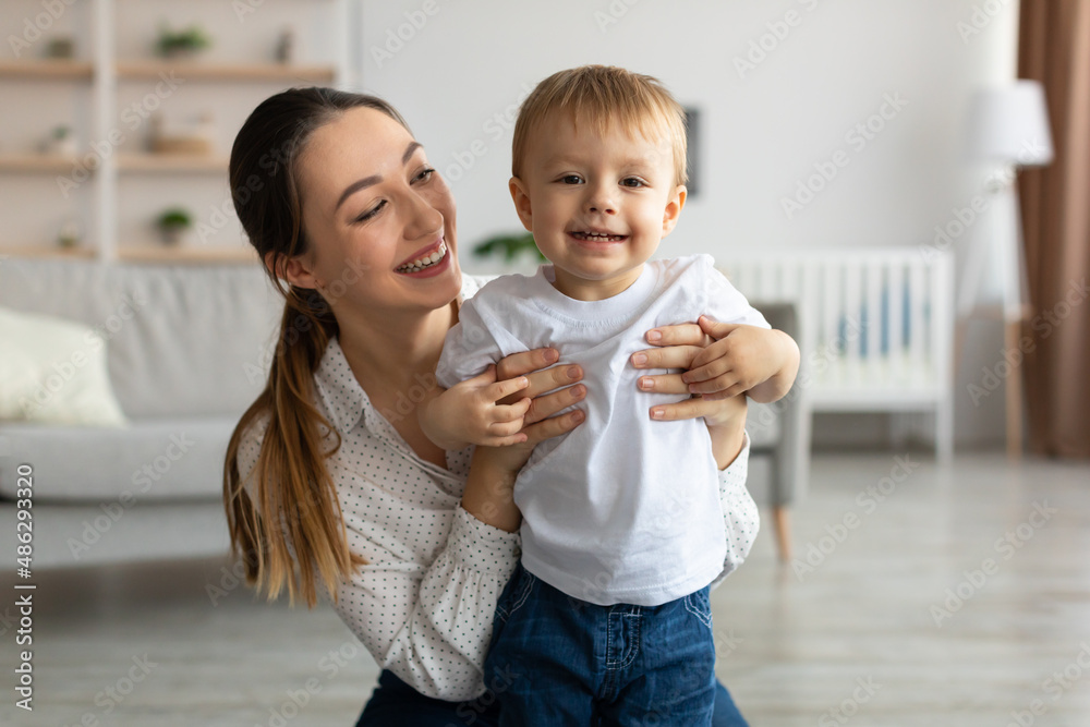 Happy maternity leave. Young mother looking at her toddler son with love and smiling, enjoying time with her baby Happy maternity leave. Young mother looking at her toddler son with love and smiling, enjoying time with her baby