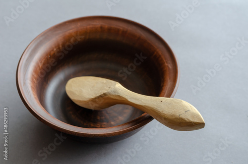 Brown earthenware bowl and buckshot against a gray background.