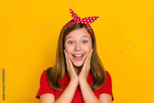 Portrait of adorable sweet positive lovely little woman touch cheekbones see ad banner isolated on yellow color background