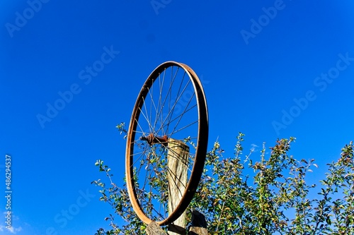 Bicycle spoke positioned as a Ferris wheel facing a blue sky photo