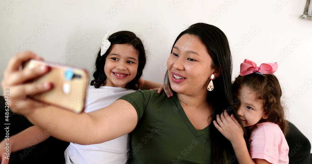 Fototapeta premium Mother holding cellphone taking photo selfie