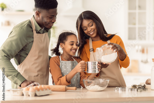 African American Family Baking Cookies Using Flour Sifter In Kitchen