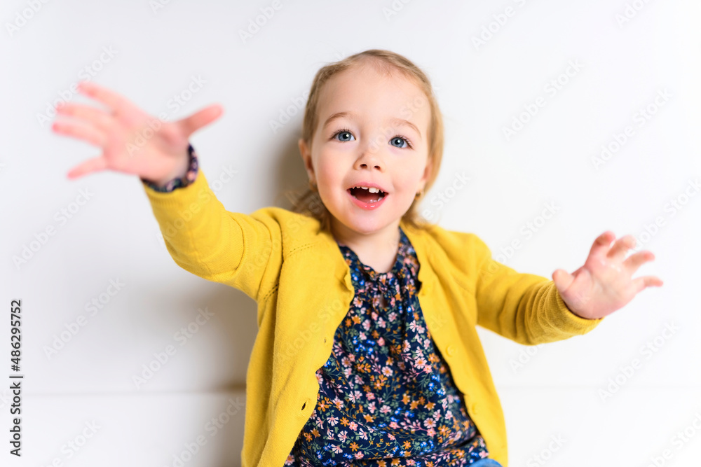 Cute playful baby girl sitting on the floor of a white background Cute playful baby girl sitting on the floor of a white background
