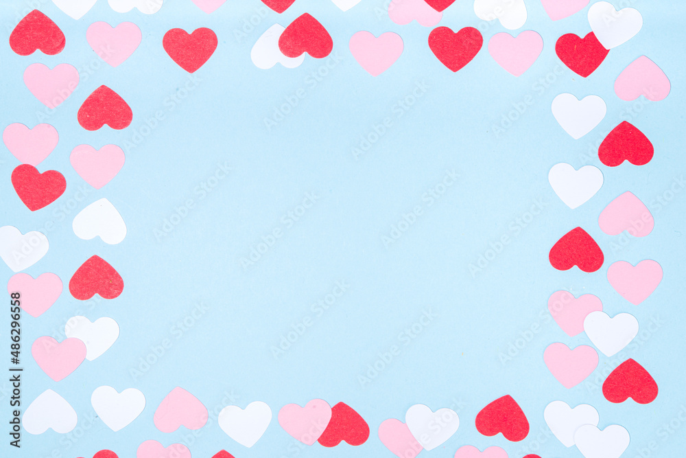 Valentine day simple greeting card flatlay. Valentines holiday background with red, pink, white hearts, pink roses, gift box, top view copy space on light blue background Valentine day simple greeting card flatlay. Valentines holiday background with red, pink, white hearts, pink roses, gift box, top view copy space on light blue background