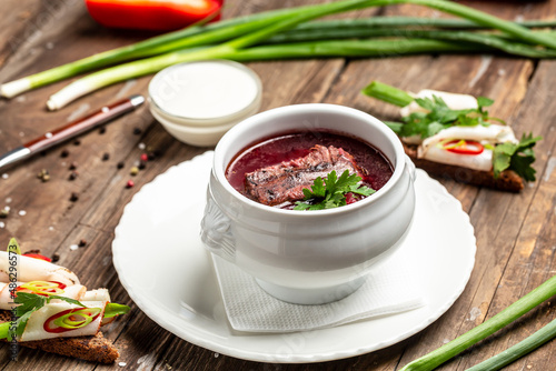Borsch, soup, beet broth with vegetables and ribs, Traditional Ukrainian cuisine, wooden background. banner, menu, recipe place for text, top view