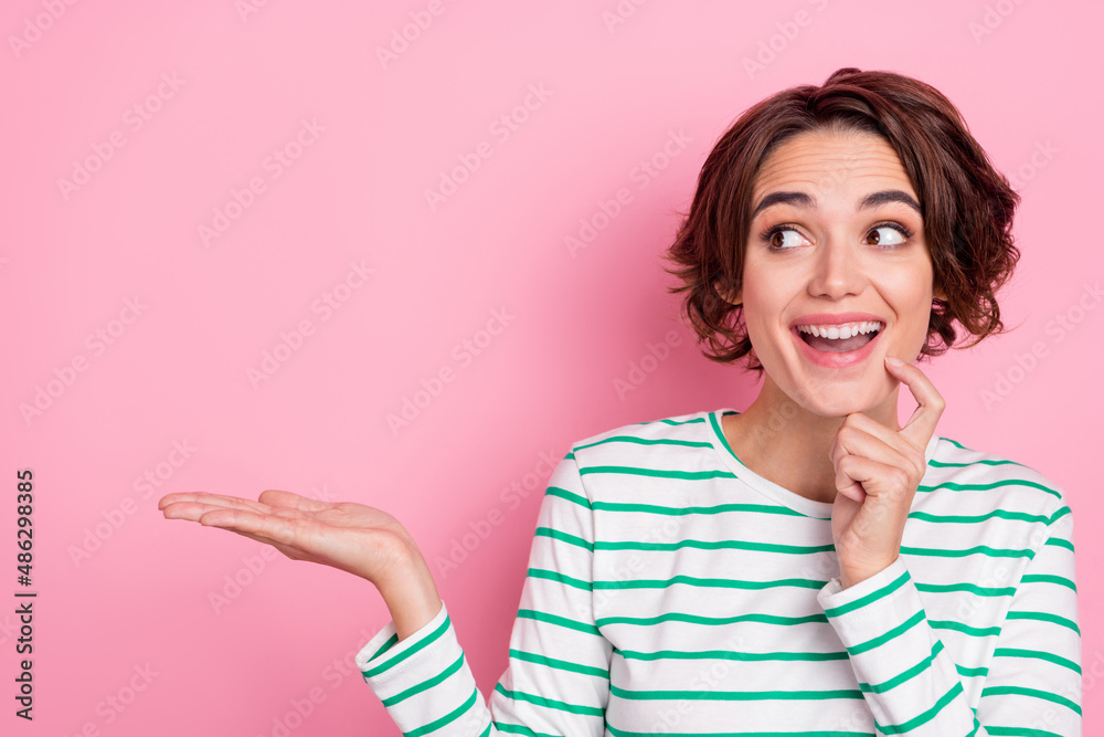 Portrait of attractive curious cheerful girl holding on palm copy space offer solution isolated over pink pastel color background Portrait of attractive curious cheerful girl holding on palm copy space offer solution isolated over pink pastel color background