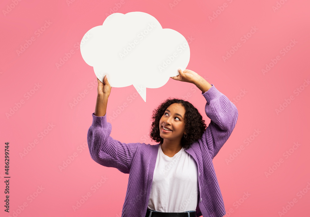 Positive black woman holding empty speech bubble above her head on pink studio background, mockup for ad design - obrazy, fototapety, plakaty 