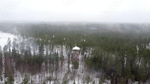 Turning aerial drone view through smoke and fog on Valgesoo viewing tower in Estonia during winter photo