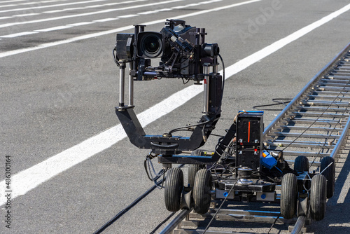 Video camera on rail carts. Specialized operator equipment. Professional video filming Concept. Rails on pavement for filming equipment. Camcorder shoots outdoors. Automatic video camera