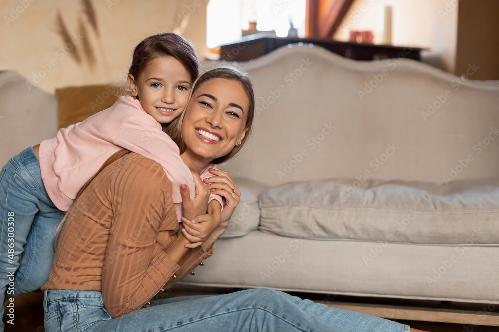 Portrait of happy young woman and daughter spending time together