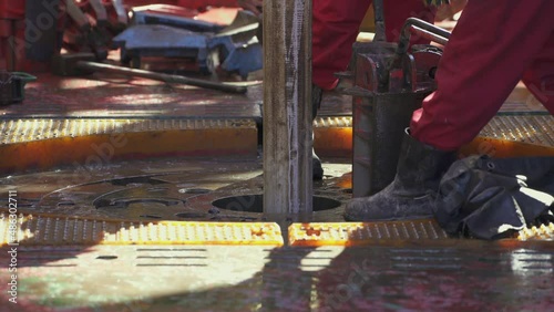Offshore drilling platform. Rotor table. Manual slips removed. Drilling pipe goes down