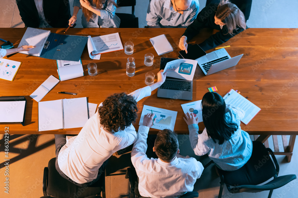 Young, motivated men and women, businessmen talking, working with colleagues, co-workers at office, indoors. Startup, finance, tech and innovation concept. Young, motivated men and women, businessmen talking, working with colleagues, co-workers at office, indoors. Startup, finance, tech and innovation concept.