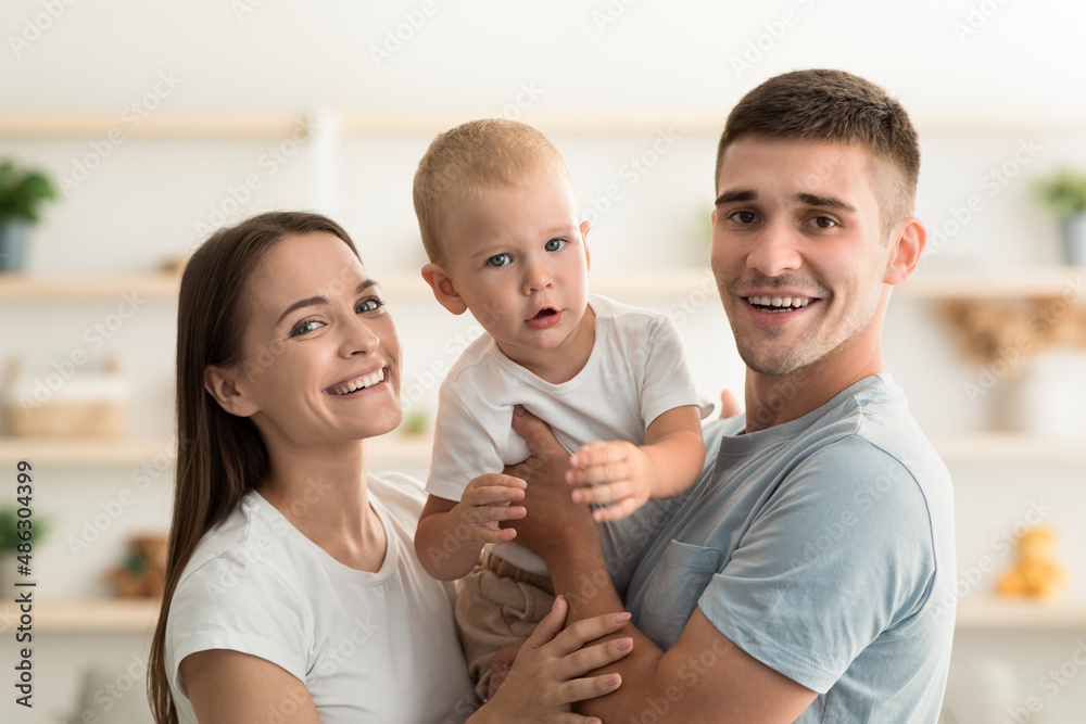 Millennial Family. Portrait Of Happy Young Mother And Father With Infant Child Millennial Family. Portrait Of Happy Young Mother And Father With Infant Child