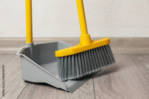 Εκτύπωση καμβά Plastic broom with dustpan on wooden floor indoors