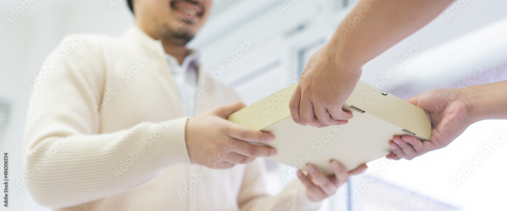 close up man hand holding box while receiving form postman for delivery business and transportation service concept close up man hand holding box while receiving form postman for delivery business and transportation service concept