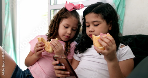 Children eating sandwich snack browsing internet