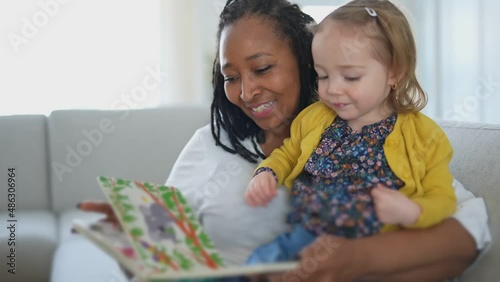 babysitter black woman read book with little child girl