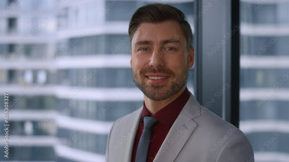 Thinking caucasian businessman smiling looking camera in modern window office. Thinking caucasian businessman smiling looking camera in modern window office.