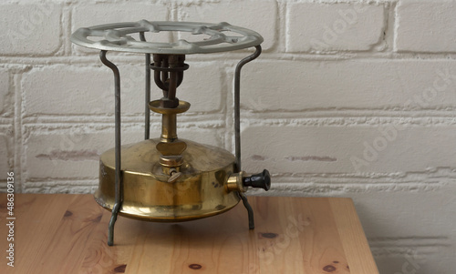 Photography old kerosene stove on the background of a white brick wall on a wooden table