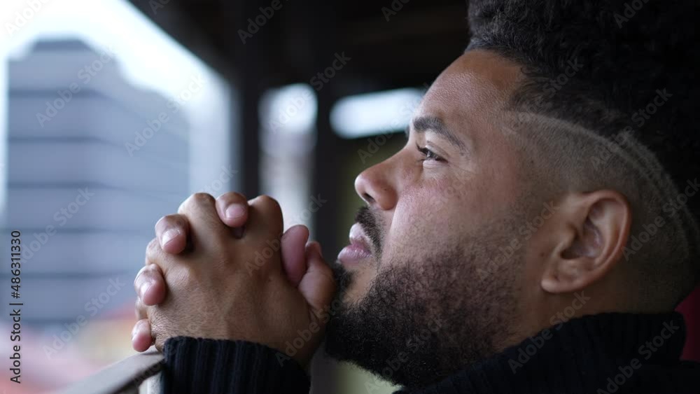 Young man seeking divine help praying to God for support Young man seeking divine help praying to God for support