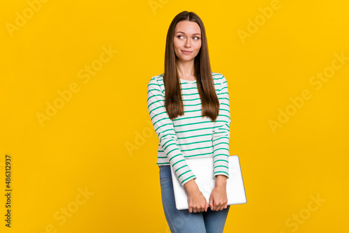 Photo of adorable dreamy woman wear striped shirt holding modern gadget empty space isolated yellow color background
