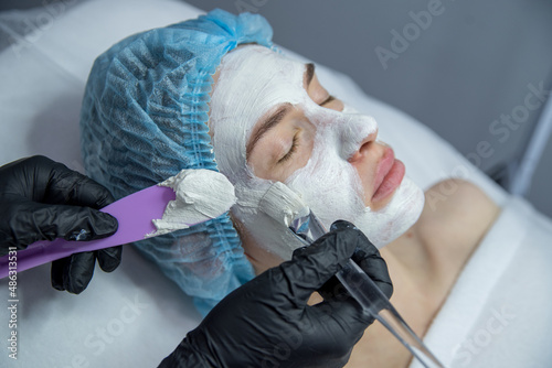 a woman at a reception at a cosmetologist performs a procedure for beautiful facial skin