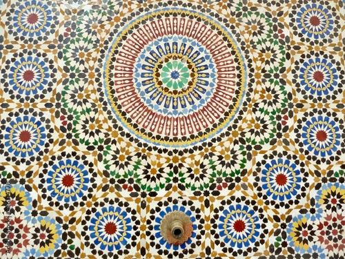 Close up traditional fountain, colorful glazes ceramic wall tiles in Islamic design. Rabat, Morocco.