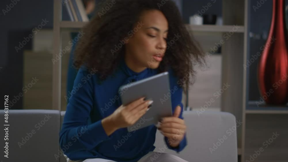 African american business lady finishing work day on tablet computer in office. African american business lady finishing work day on tablet computer in office.