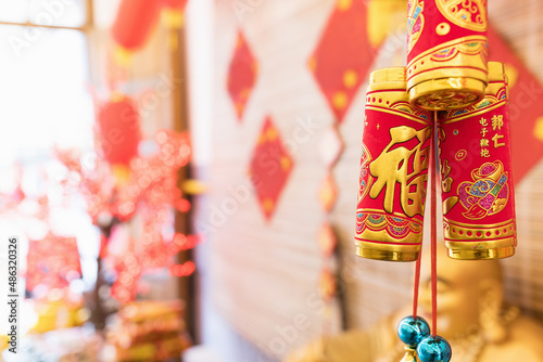 Celebration of Chinese Lunar New Year concept. The traditional Chinese red and gold decoration and firecrackers hang to scare away evil spirits and bad luck. Protection and security of home in new