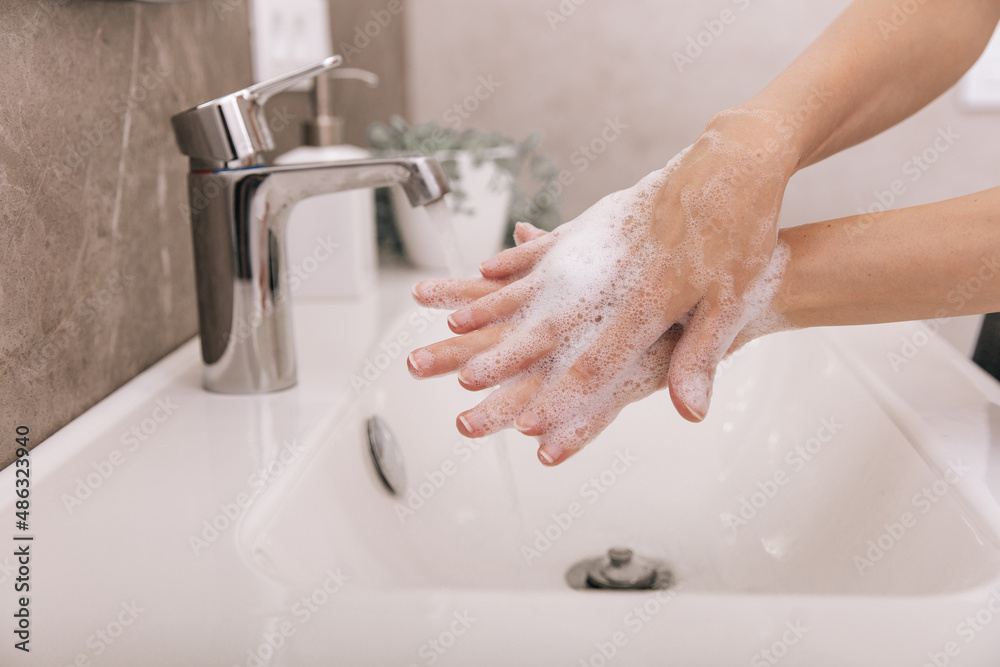 Washing hands under the flowing water tap. Hygiene concept hand detail. Washing hands rubbing with soap for corona virus prevention, hygiene to stop spreading corona virus in or public wash room. Washing hands under the flowing water tap. Hygiene concept hand detail. Washing hands rubbing with soap for corona virus prevention, hygiene to stop spreading corona virus in or public wash room.