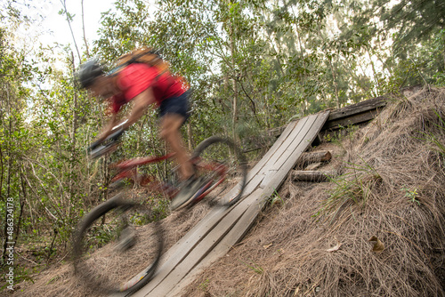 Obraz na płótnie Man going downhill on a mountain bike with motion blur w salonie