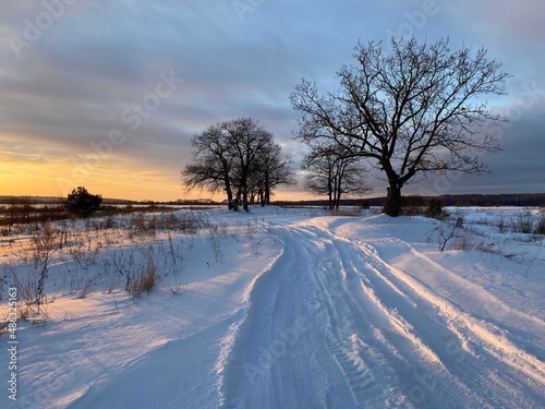 Winter dirt road along the forest. Winter landscape.