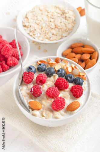 Oatmeal porridge with raspberries, blueberries and nuts