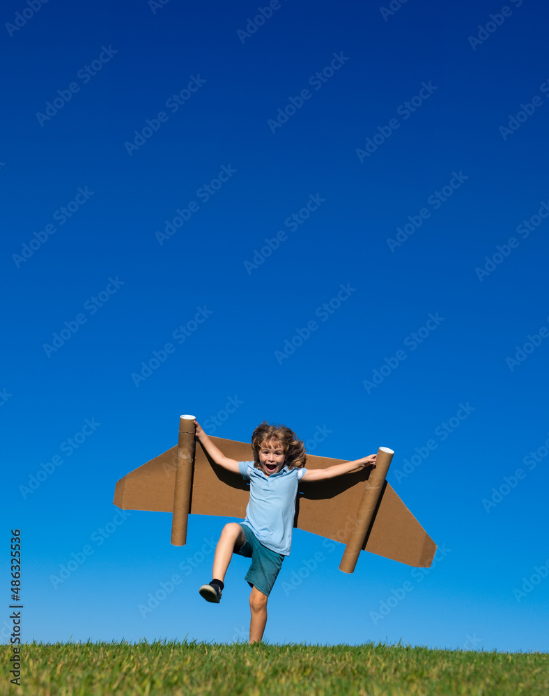 Kid pilot with toy jetpack against sky background. Happy child playing outdoors. Happy childhood. Children imagination concept. Kid pilot with toy jetpack against sky background. Happy child playing outdoors. Happy childhood. Children imagination concept.