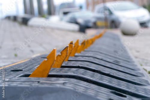 Close-up of yellow spikes for a tire puncture is a stop line with a large spike for stopping the car. Tire spikes used at the entrance and exit to the park, hotel or security zones photo