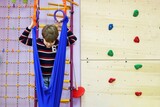 child boy learns to communicate with children through climbing training in a children's rehabilitation center for children with diseases and developmental disabilities