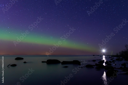 Arcuate aurora green above the lake with lighthouse
