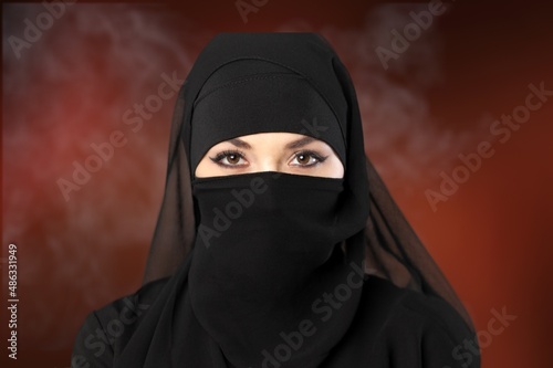 Tableau sur toile Portrait of young woman in black burqa with hidden face,