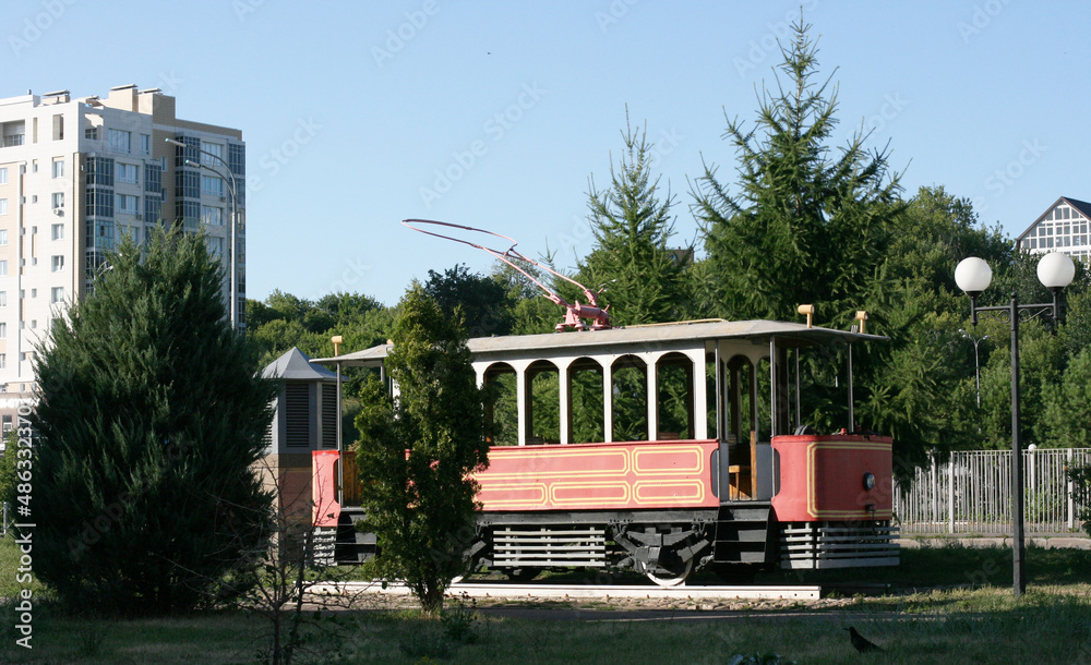 Naklejka premium Kazan street in summer, Tatarstan, Russia - July 18 2021v- Retro tram. Place is tourist attraction of Kazan. Girl having fun with old vintage tramway. Transport, people travel and sightseeing concept.