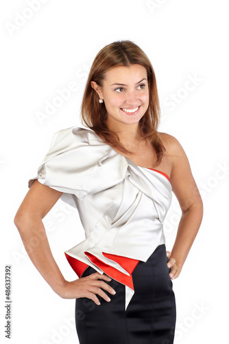 Smiling beautiful young woman in black white red dress, standing and looking at camera. Studio shot, cropped mid-thigh, isolated on white