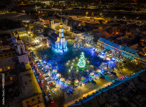 Aerial panoramic drone photo of Kaunas Old Town with a Christmas market and a Christmas tree with decorations at night © Audrius