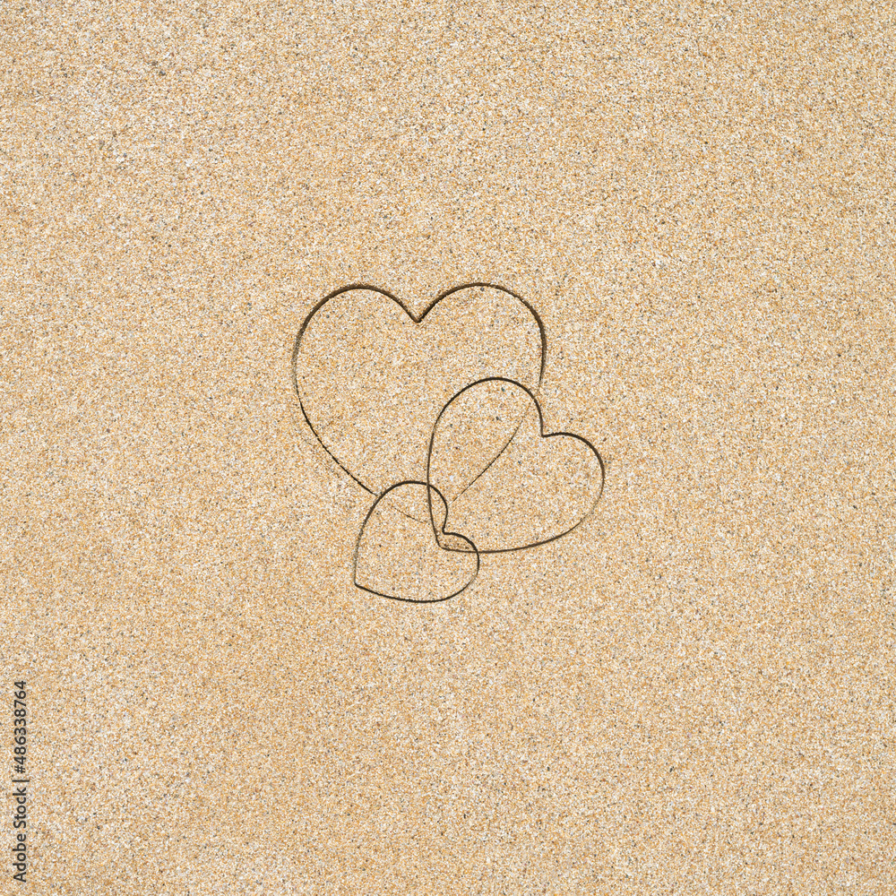 Hand-drawn shape of three heart on sand tropical beach. valentines day. Holiday, the vacation of family, friends concept. Creative, background, copy space, travel, summer. Flat lay