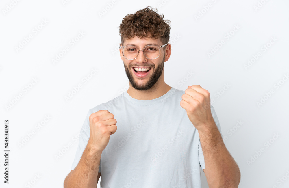 Young handsome caucasian man isolated on white background With glasses and celebrating a victory