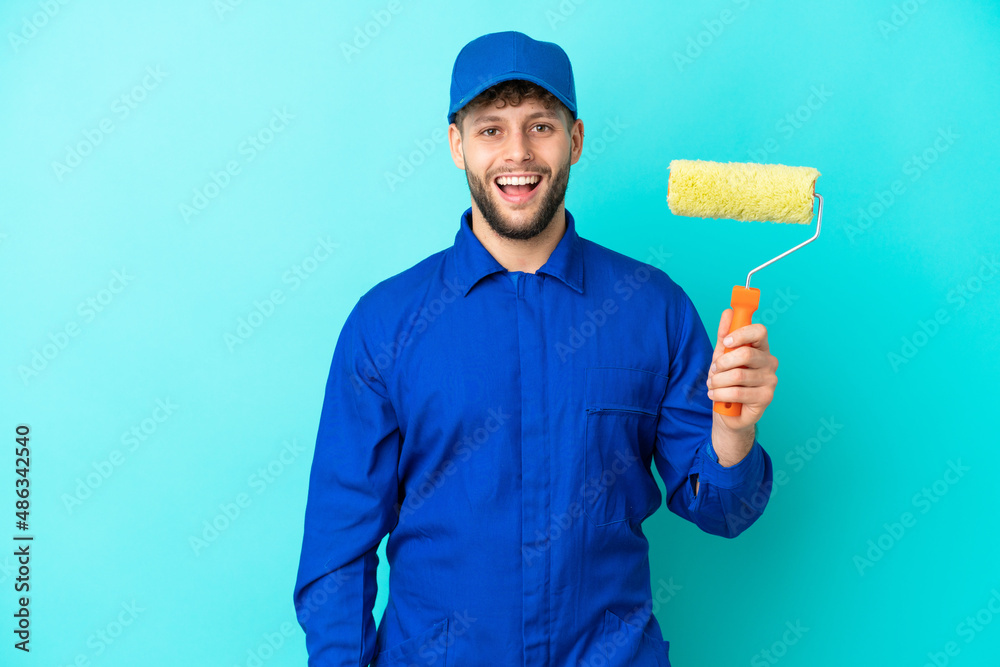 Painter caucasian man isolated on blue background with surprise facial expression
