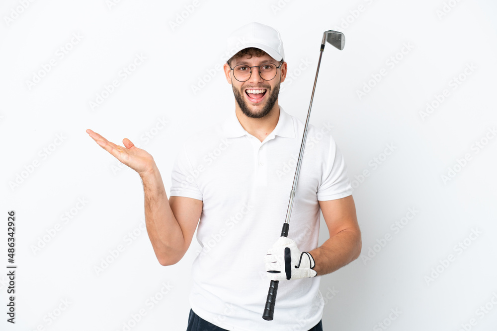 Handsome young man playing golf isolated on white background with shocked facial expression Handsome young man playing golf isolated on white background with shocked facial expression