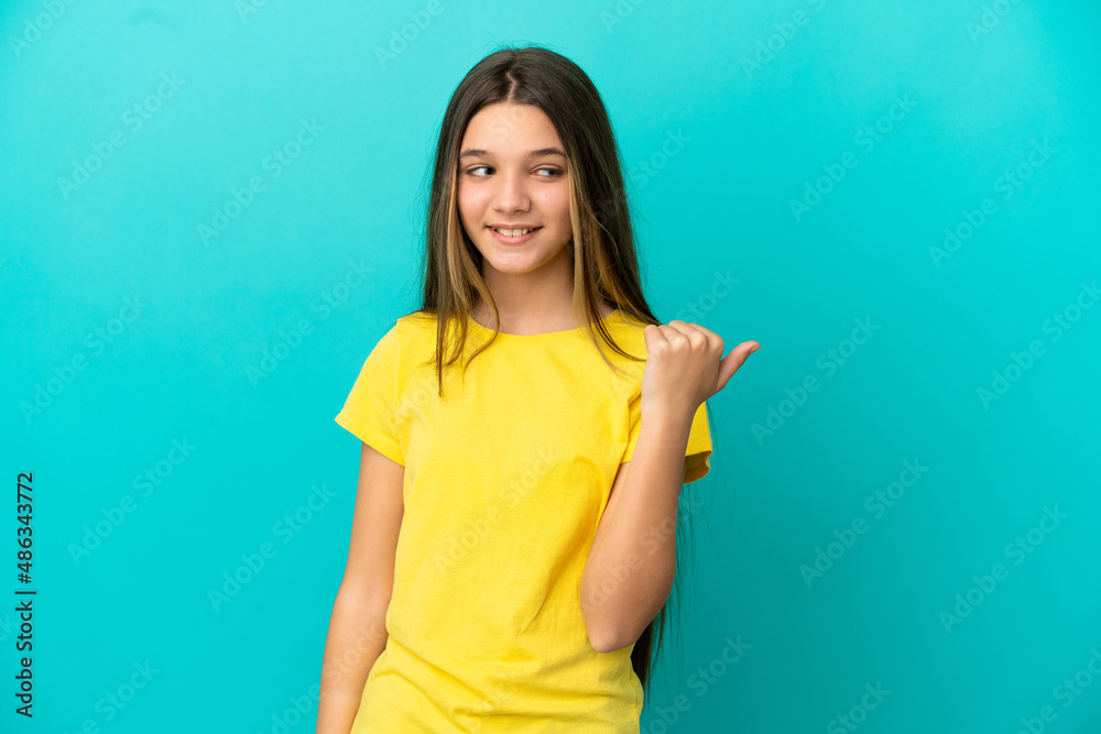 Little girl over isolated blue background pointing to the side to present a product Little girl over isolated blue background pointing to the side to present a product