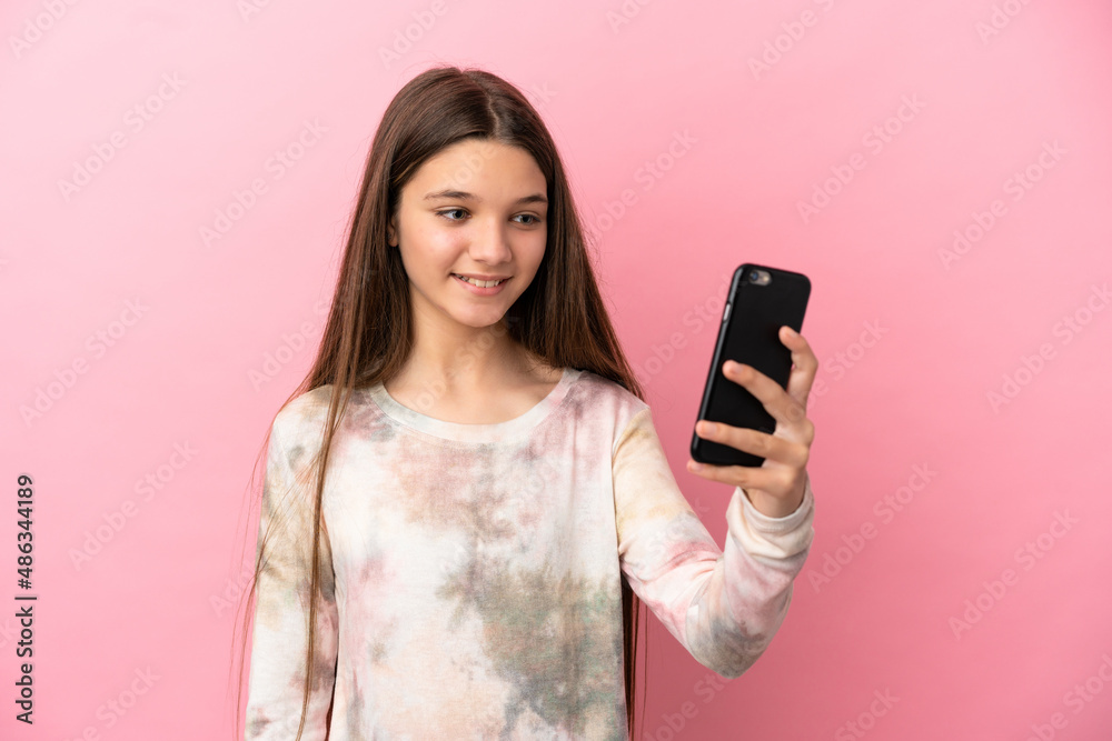 Little girl over isolated pink background making a selfie Little girl over isolated pink background making a selfie