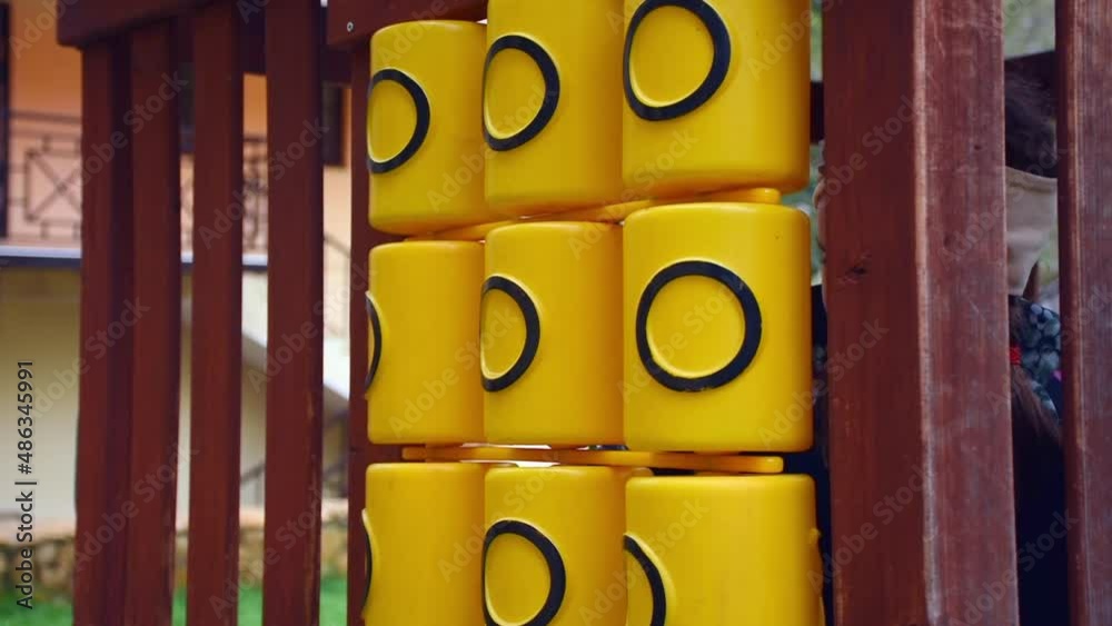 Tic Tac Toe game on playground equipment in the park. girl plays tic-tac-toe. Tic-tac-toe on the playground. The girl rotates cylinders with crosses.
