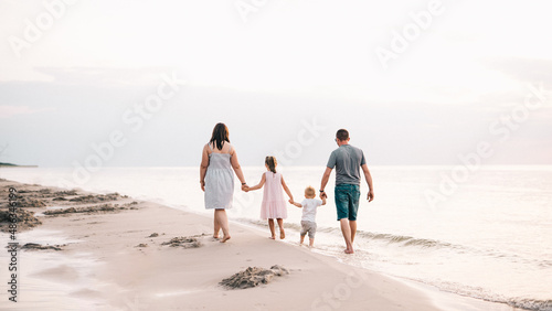 Spacerująca brzegiem morza rodzina