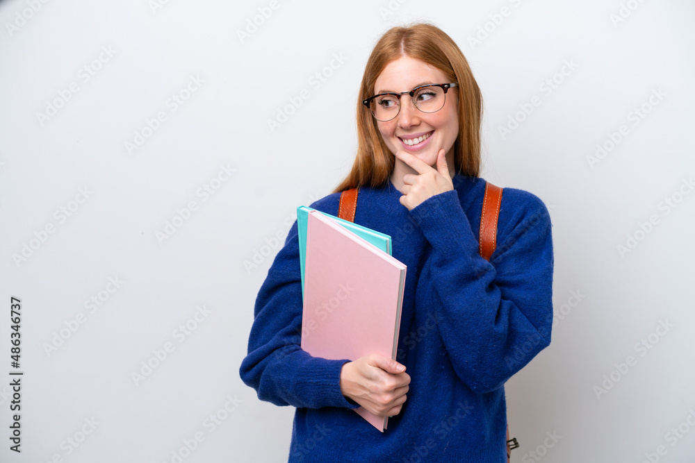 Young student redhead woman isolated on white background looking to the side and smiling Young student redhead woman isolated on white background looking to the side and smiling